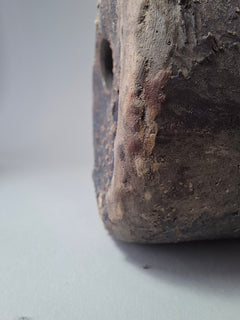 Clos,e-up of the textured surface of Rubble Vase II showing anthracite stoneware, iron oxide marks and the rough mineral texture around the rim.