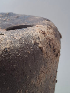 Close-up of the top of Rubble Vase II, showing the small hand-cut opening, textured rim and irregular iron oxide surface.