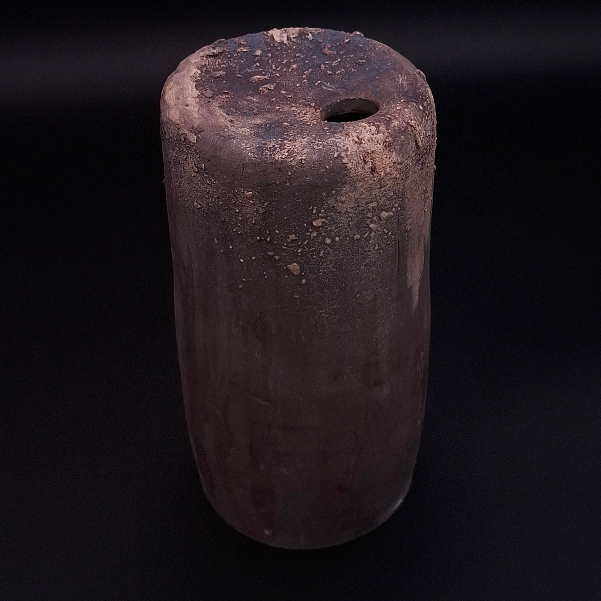 Handmade Rubble Vase II in anthracite stoneware with an iron oxide surface and textured mineral details, shown against a black background.