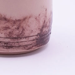 Close-up of the natural iron oxide pattern on a handmade cream stoneware Yunomi cup, showing the irregular texture and carved horizontal lines.