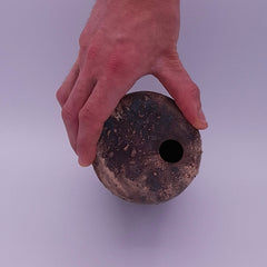 Top view of handmade Rubble Vase III in anthracite stoneware, showing the small opening and irregular burnished mineral surface held in one hand.