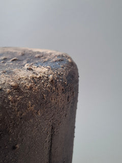 Close-up detail of the handmade anthracite stoneware surface of Rubble Vase II, showing its rough texture, iron oxide marks and irregular mineral details.