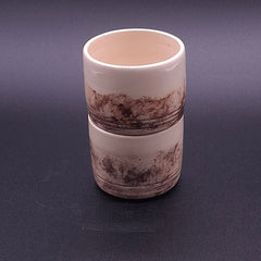 Two handmade 200 ml Yunomi cups stacked together, showing their cream stoneware surfaces and irregular natural iron oxide patterns.