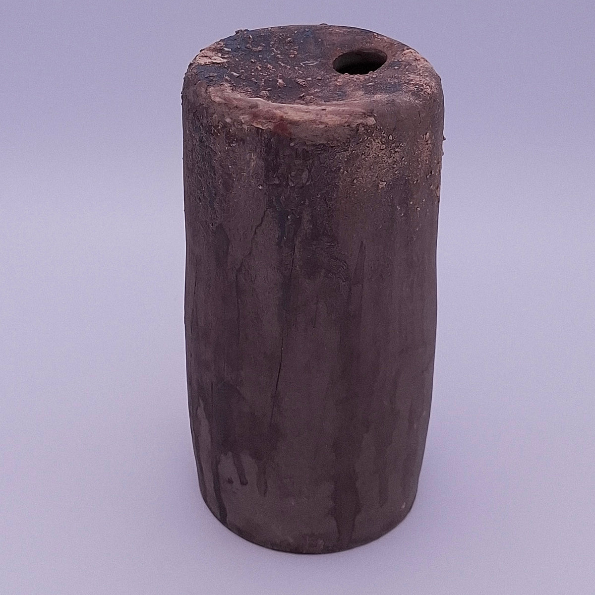 Handmade Rubble Vase II in dark anthracite stoneware, showing its irregular iron oxide surface, textured rim and narrow opening against a light background.