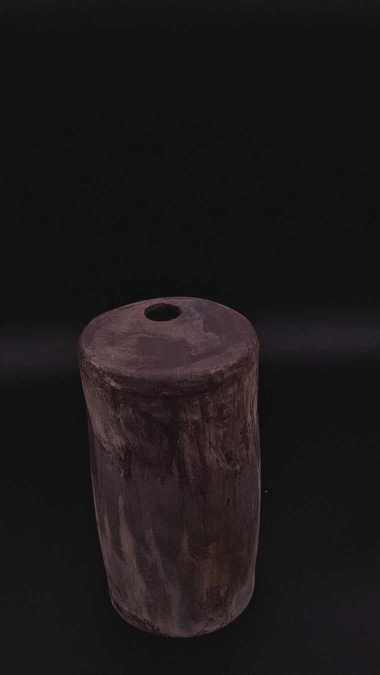 Handmade Rubble Vase III in anthracite stoneware, showing its burnished mineral surface, cylindrical form and small hand-cut opening against a dark background.